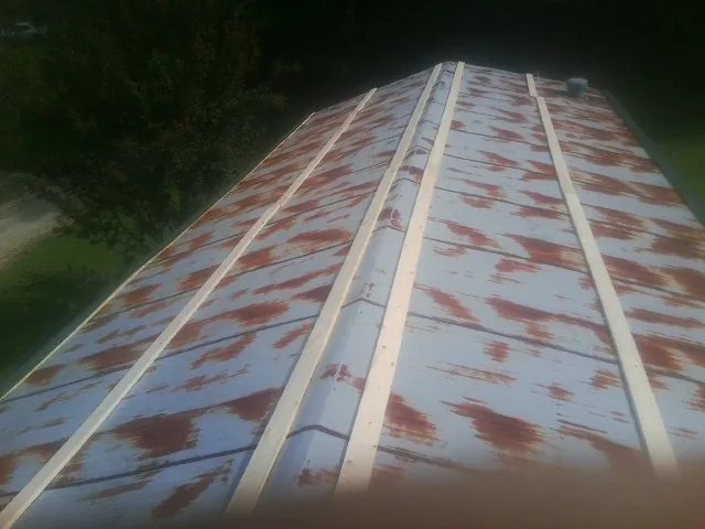Rusted metal roof panels with new wood purlins before replacement — Storm Damage Roof Repair in Wiggins by Roofing Brothers